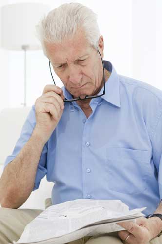 A photo of an older gentleman struggling to read something ona  tablet