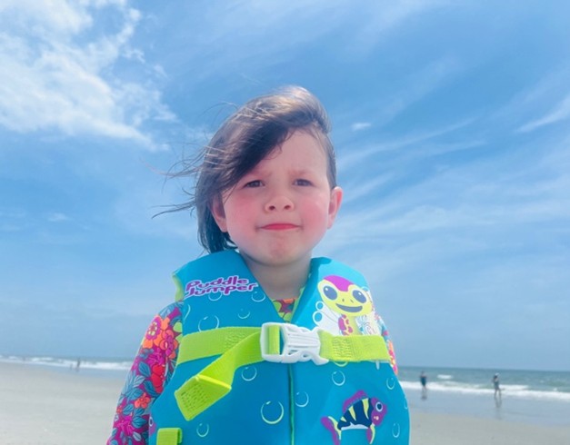 Ranzi's second child on a day at the beach wearing a life vest