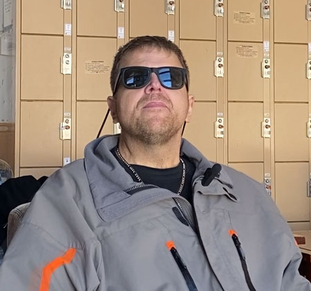 Brian sitting in front of a row of lockers