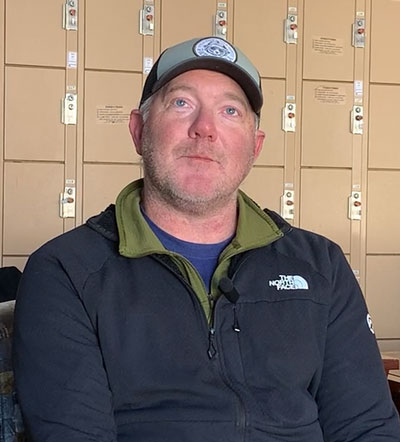 David sitting in front of a row of lockers