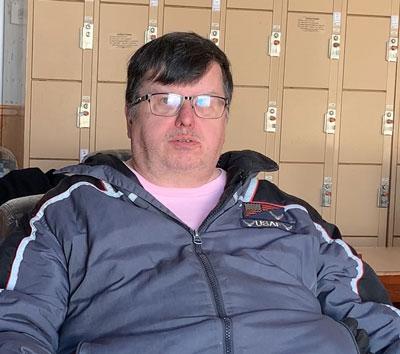 Mike sitting in front of a row of lockers